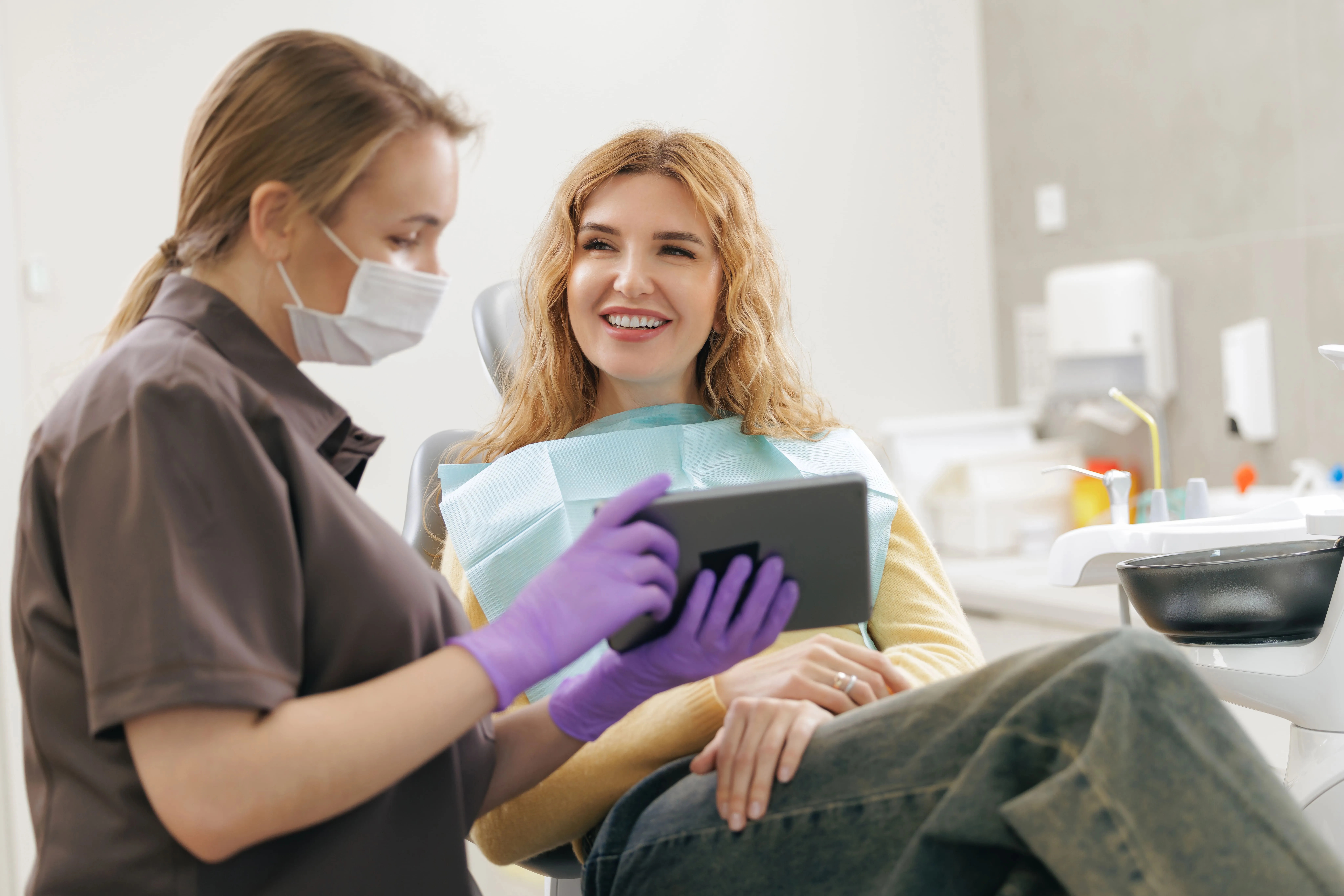 Dental professional reviewing treatment information on a tablet with a smiling patient