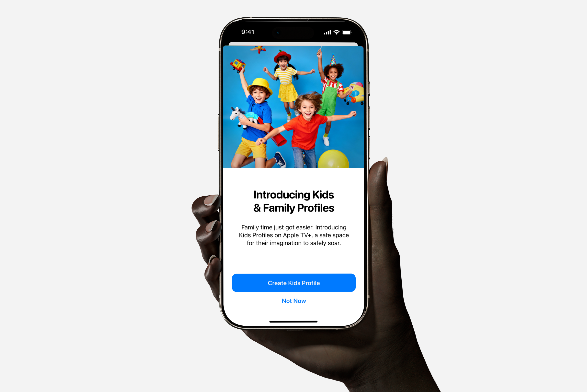 Hand holding phone showing Kids & Family Profiles intro screen with children playing and app buttons.