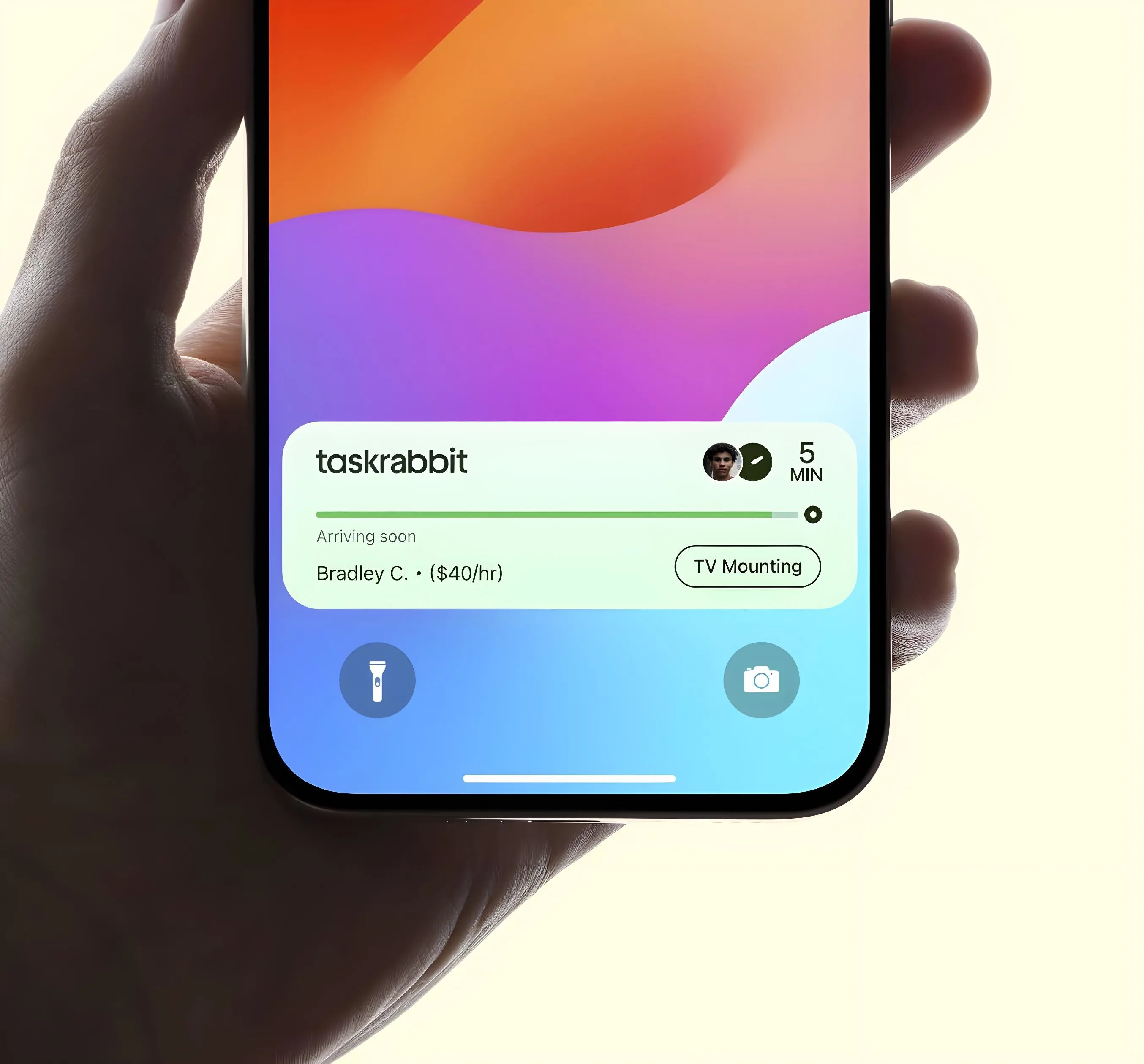 Hand holding phone showing Taskrabbit notification: Bradley C. arriving soon for TV mounting at $40/hr.