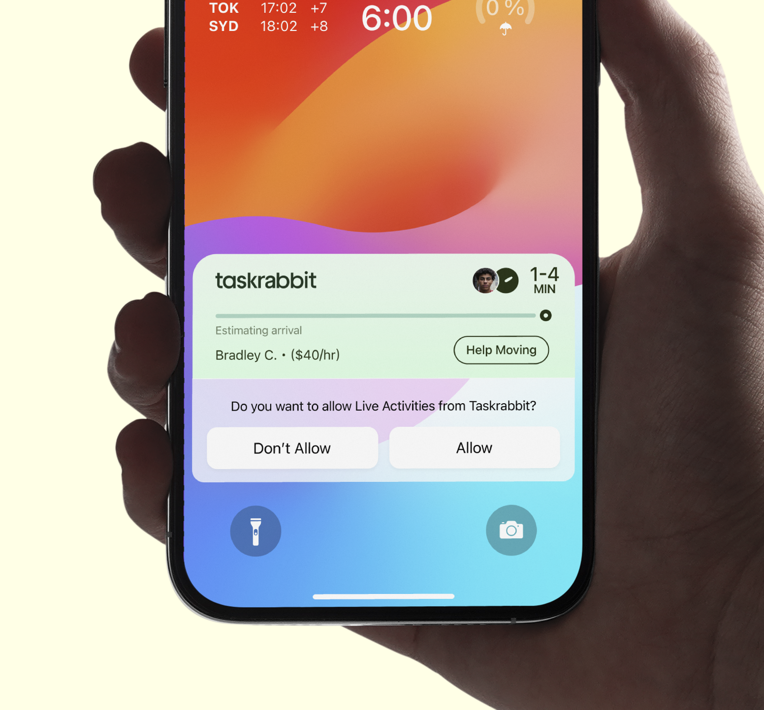 Hand holding phone showing taskrabbit app asking to allow live activities, with help moving service details.
