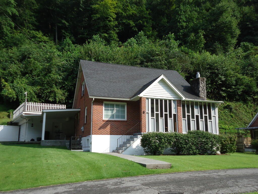 1950 Brick in Welch with Hardwood Floors, Two-Car Garage, and Half-Acre Level Lot — $97,500