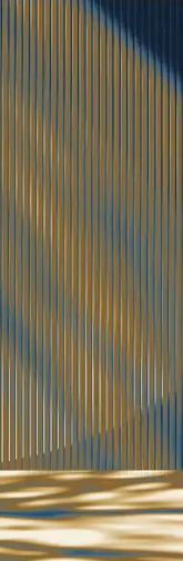 Abstract vertical ribbing crossed by diagonal light and shadow in blue and gold.