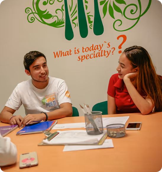 Alumnos de Inglés Individual practicando conversación en una mesa de trabajo
