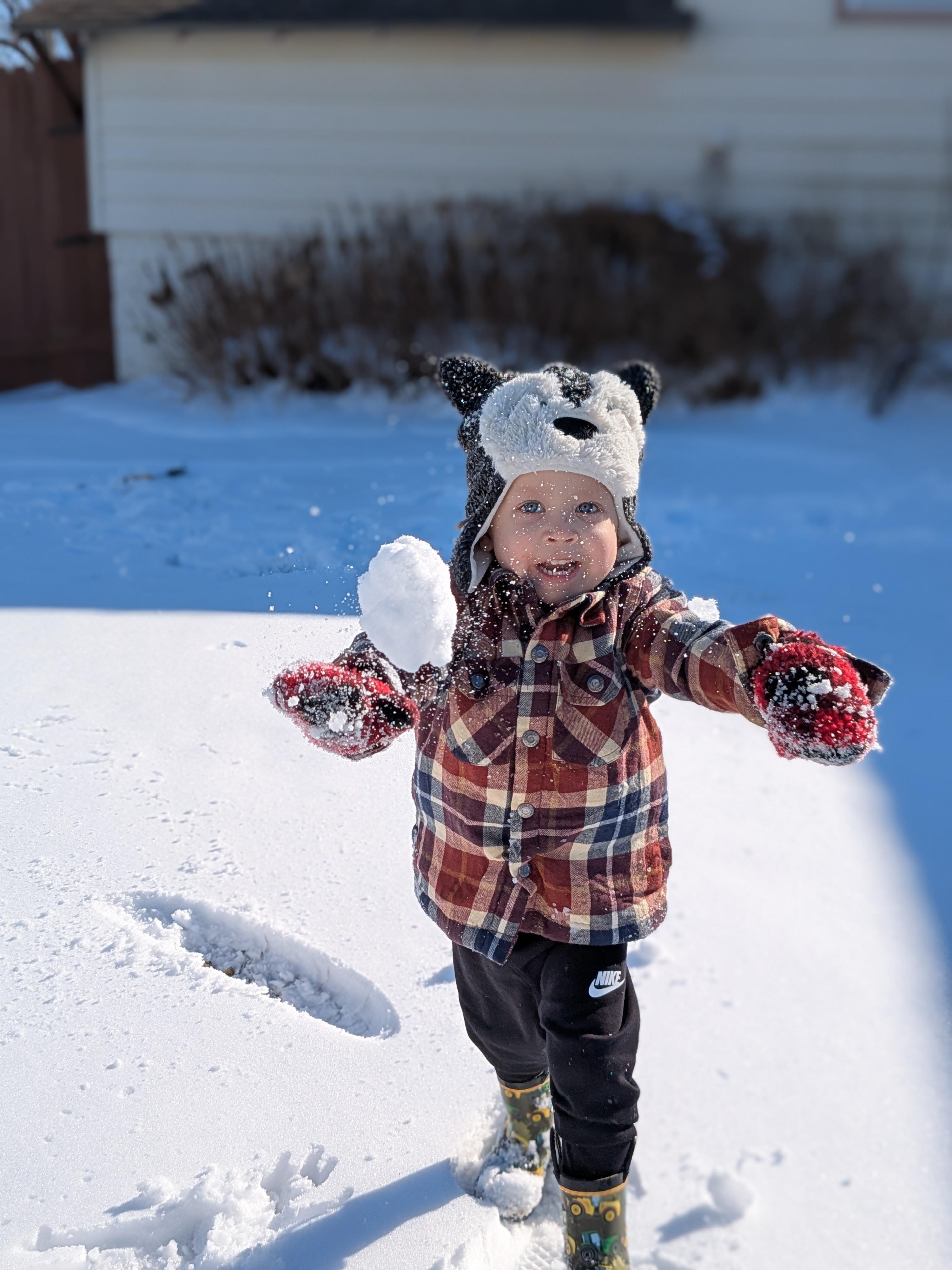 Luke laughing while playing in the snow