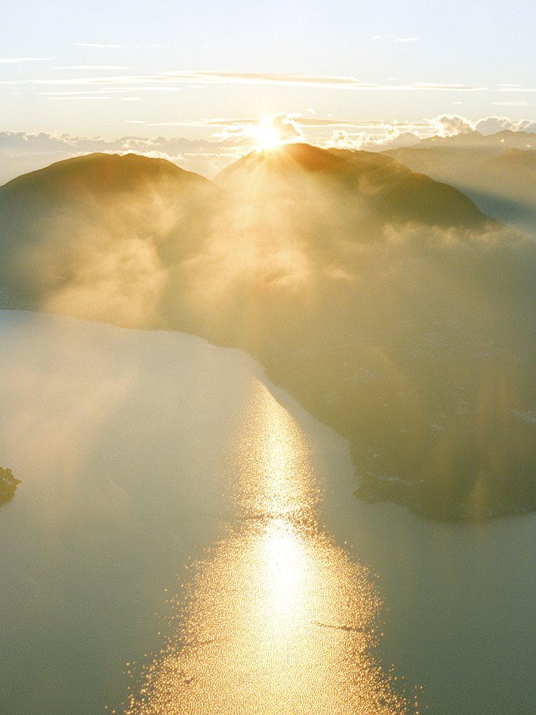 First light over Lake Lugano, a path of light on the water