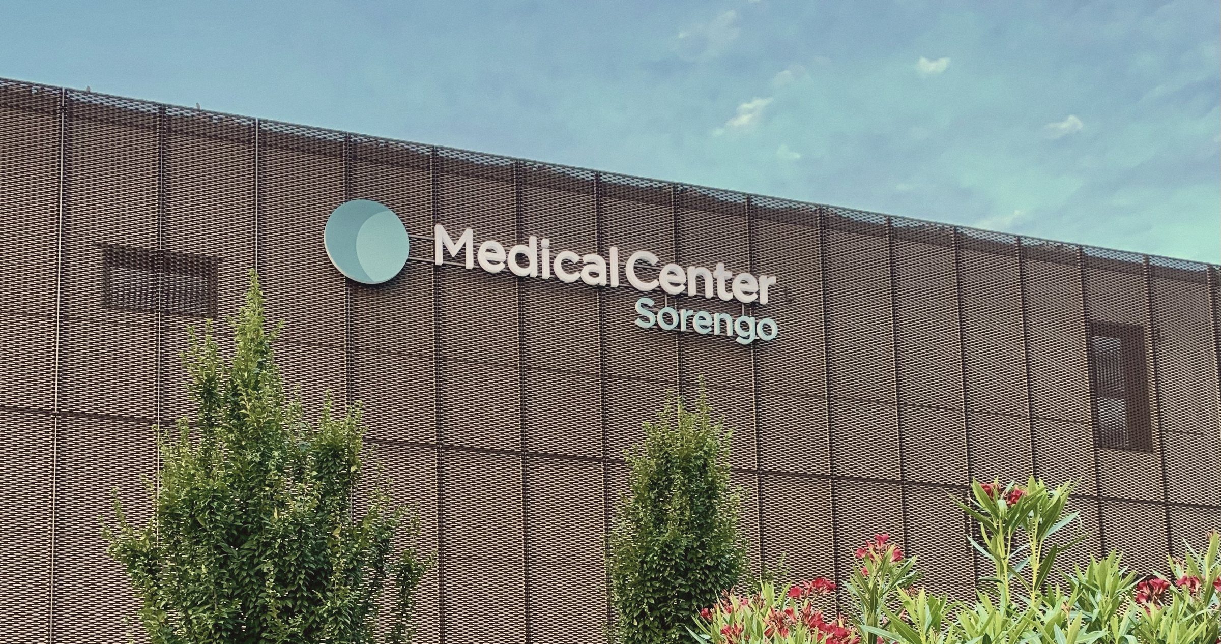 The facade of Medical Center Sorengo among oleanders and young trees