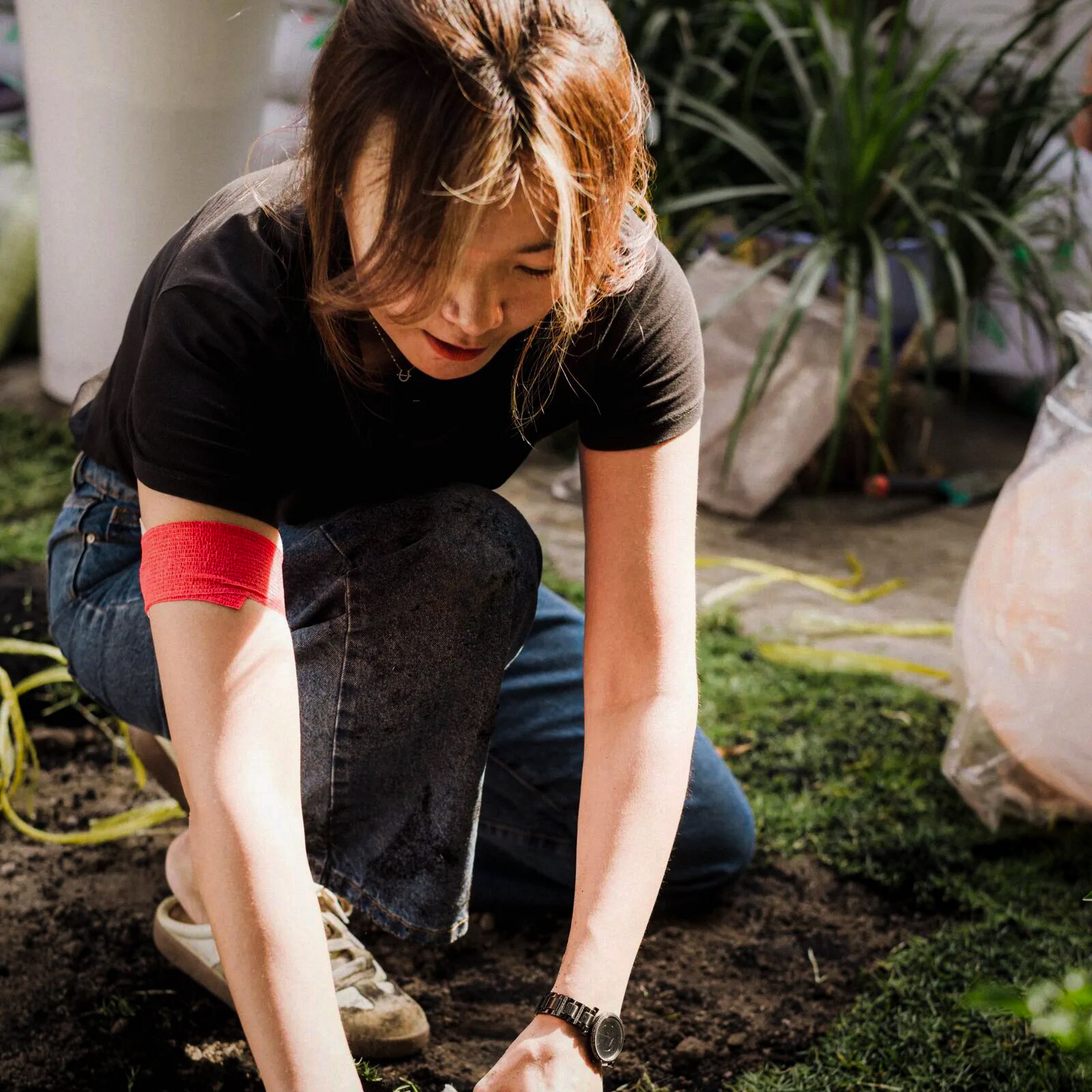 Florist kneeling and planting in garden soil