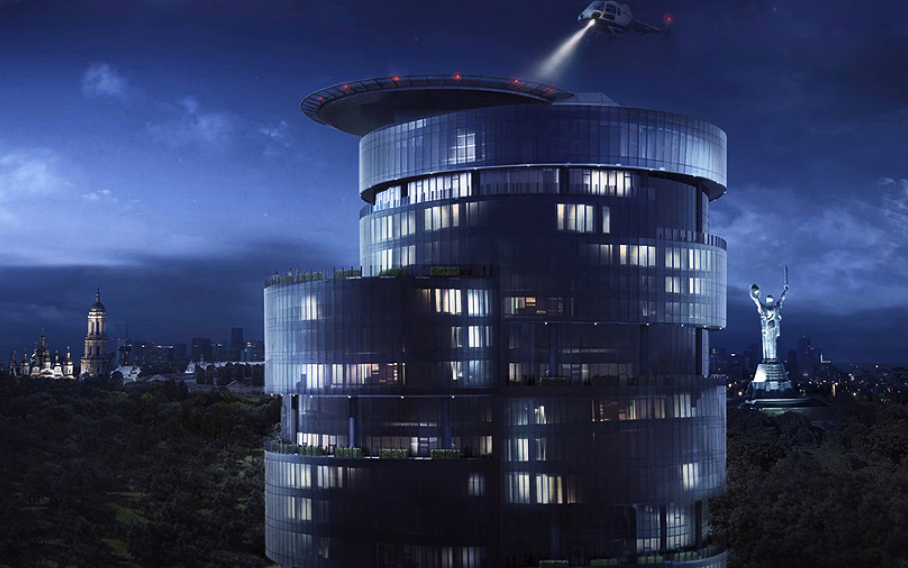 Modern cylindrical glass building lit at night with helicopter searchlight and statue in background.