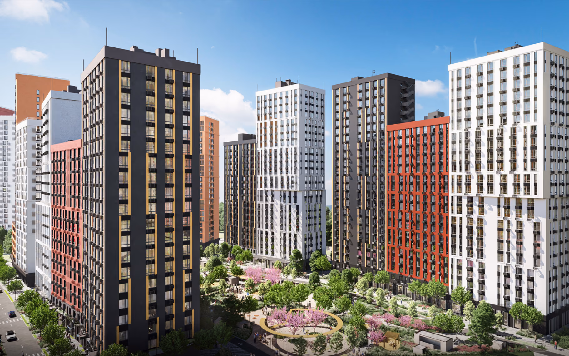 Modern tall apartment buildings surround a landscaped park with trees and walking paths under a blue sky.