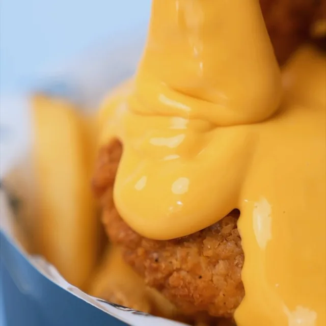 Cheese sauce poured over crispy chicken