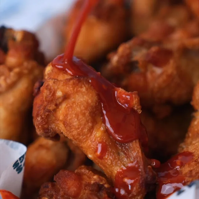 Hot sauce poured over crispy wings