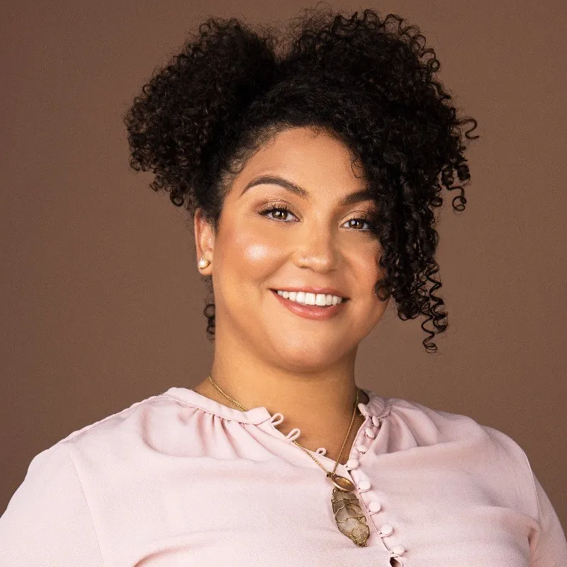 Headshot of Dr Andrea Jacobo in front of a plain brown background