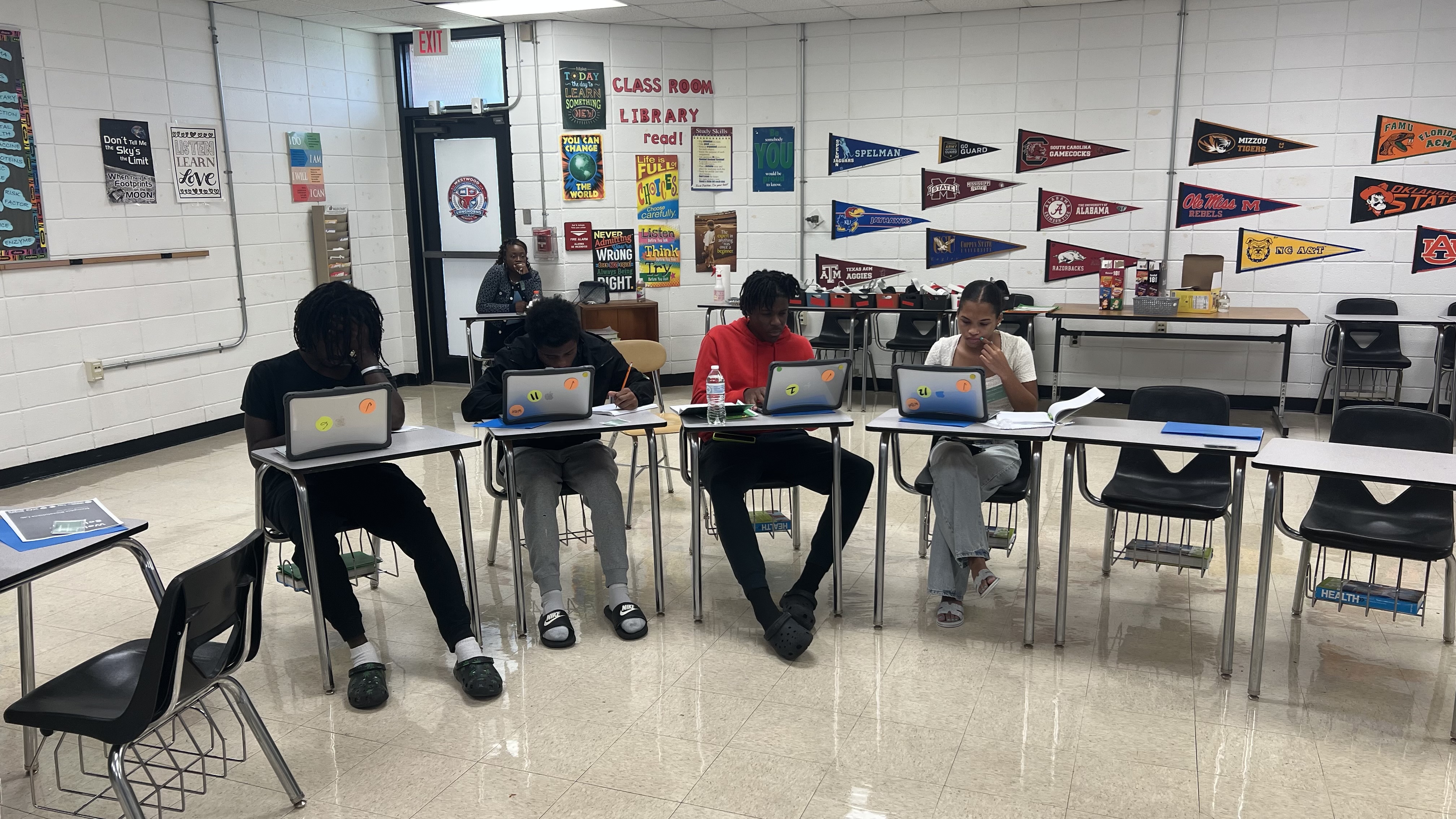 A team of young scientists researching a pollution solution together on their laptops