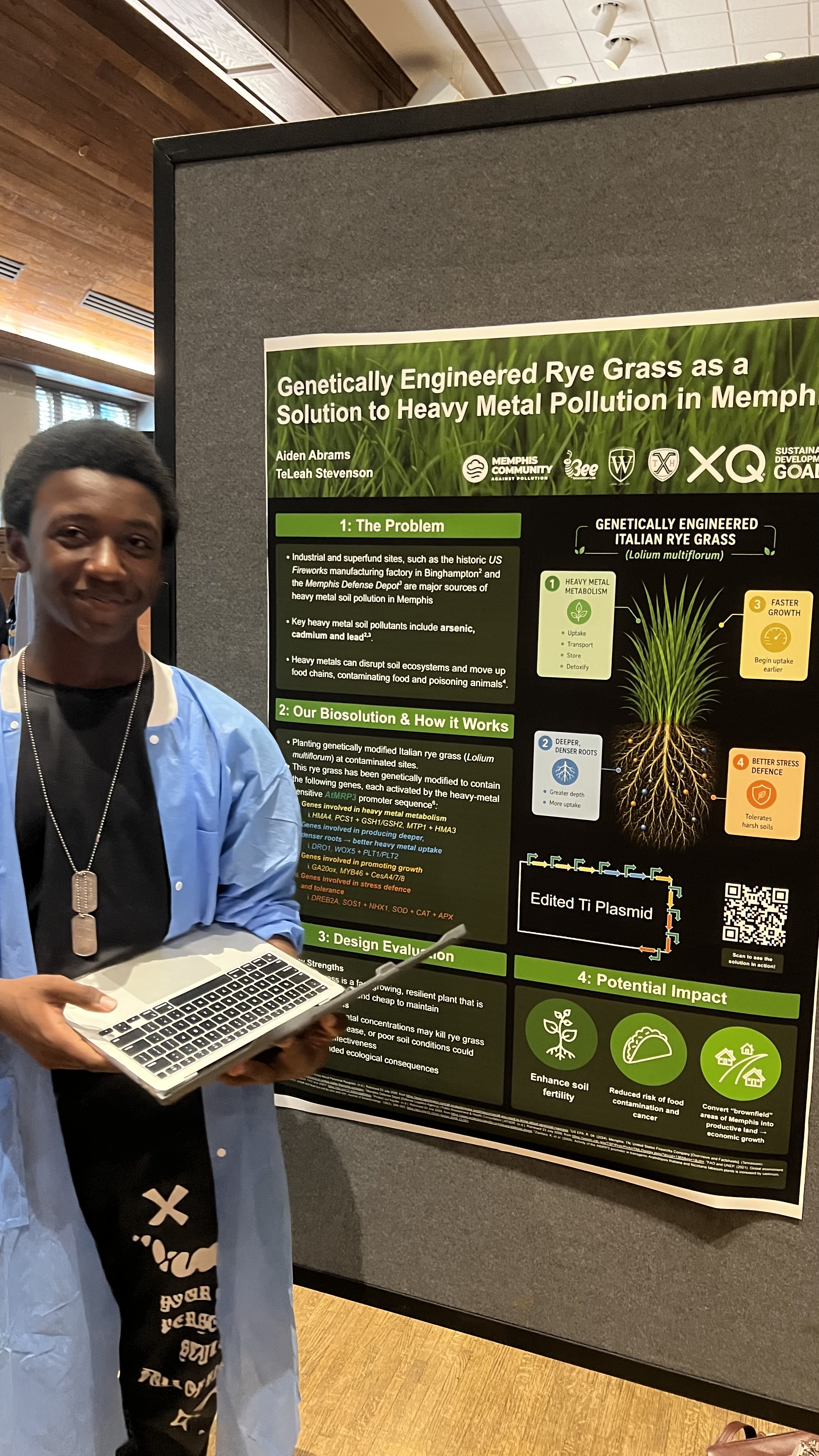 A young scientist presenting his poster on genetically engineered rye grass as a solution to heavy metal soil poisoning