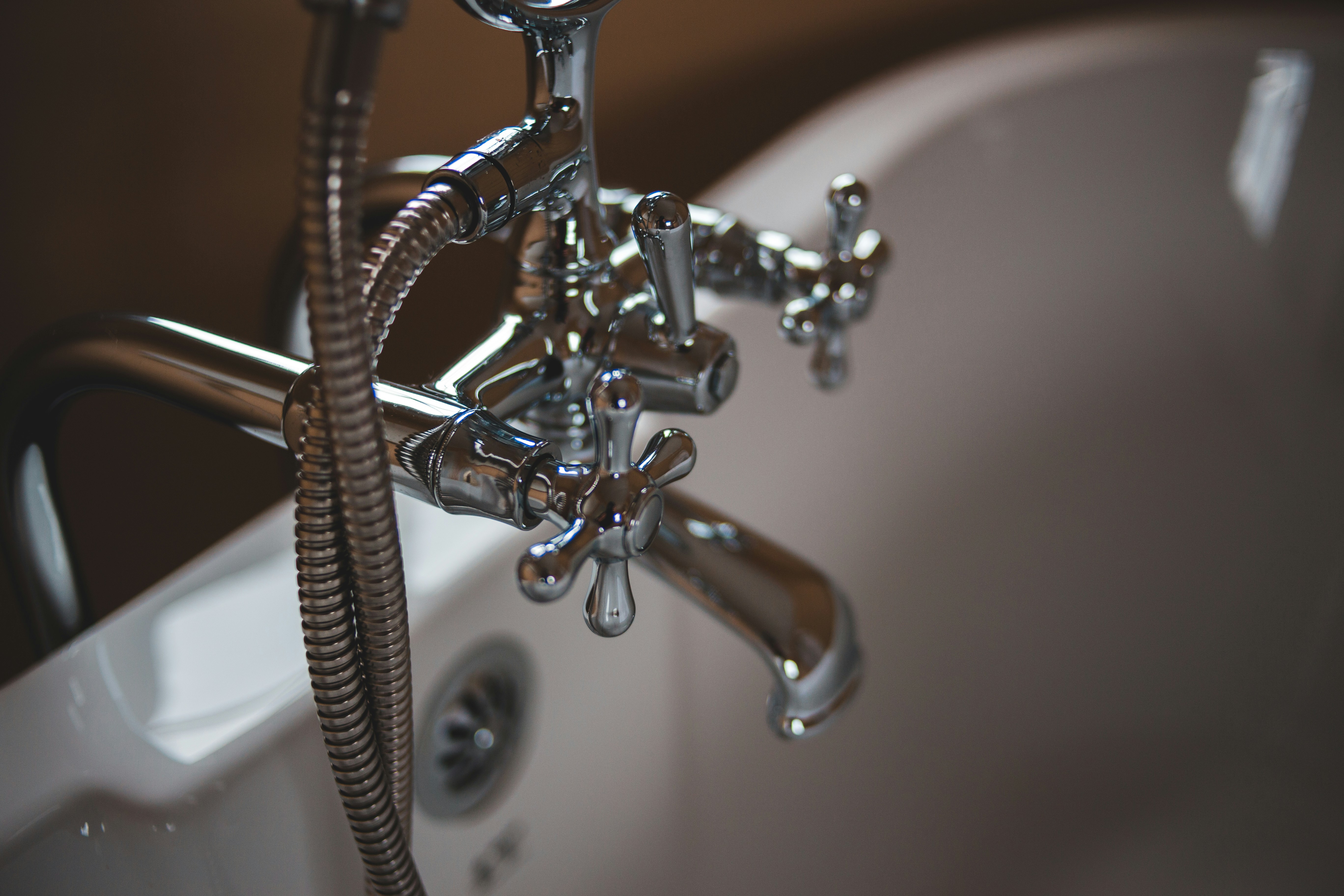 Professional plumber repairing a leaking pipe beneath a kitchen sink.
