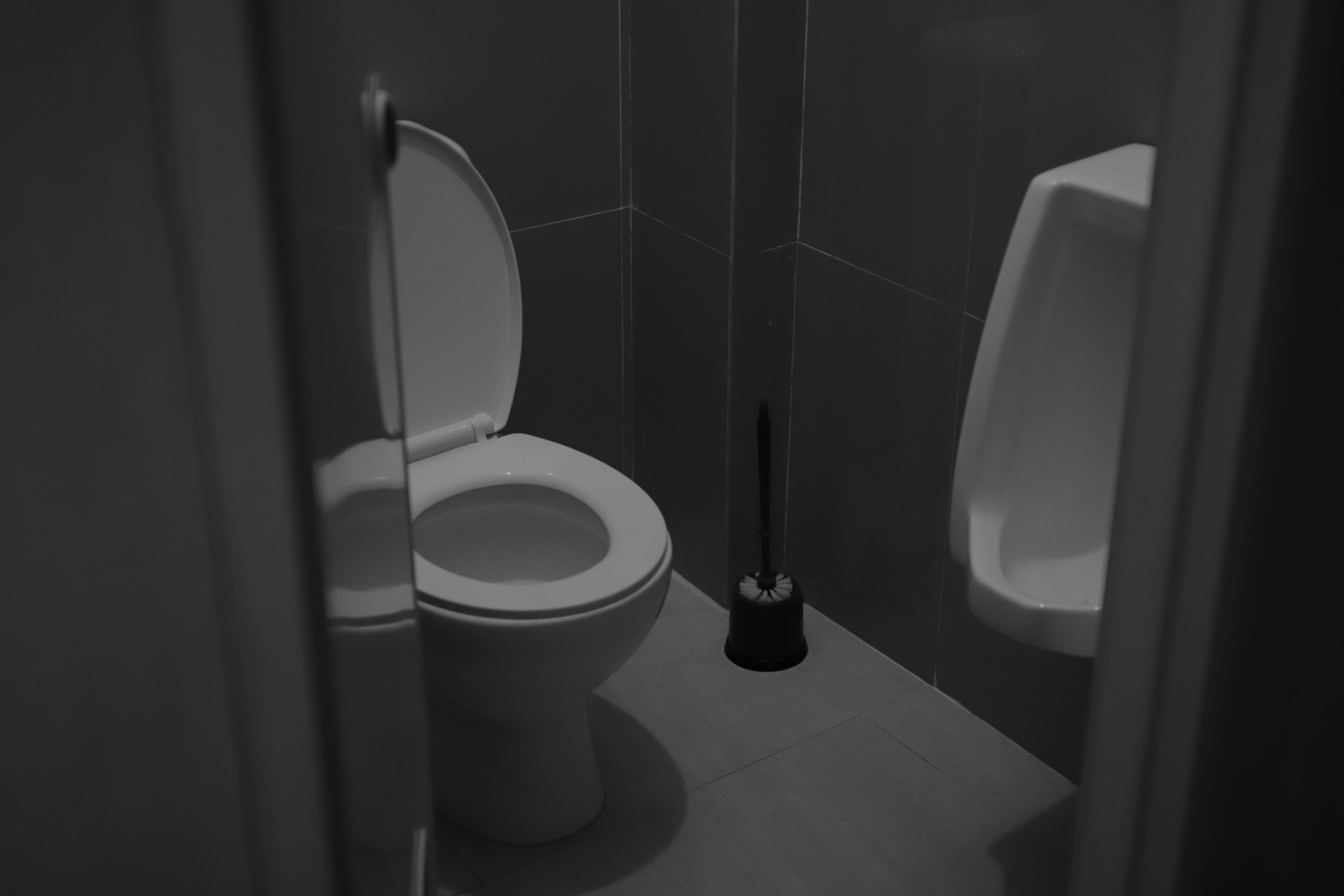 Plumber installing a modern toilet in a residential bathroom.