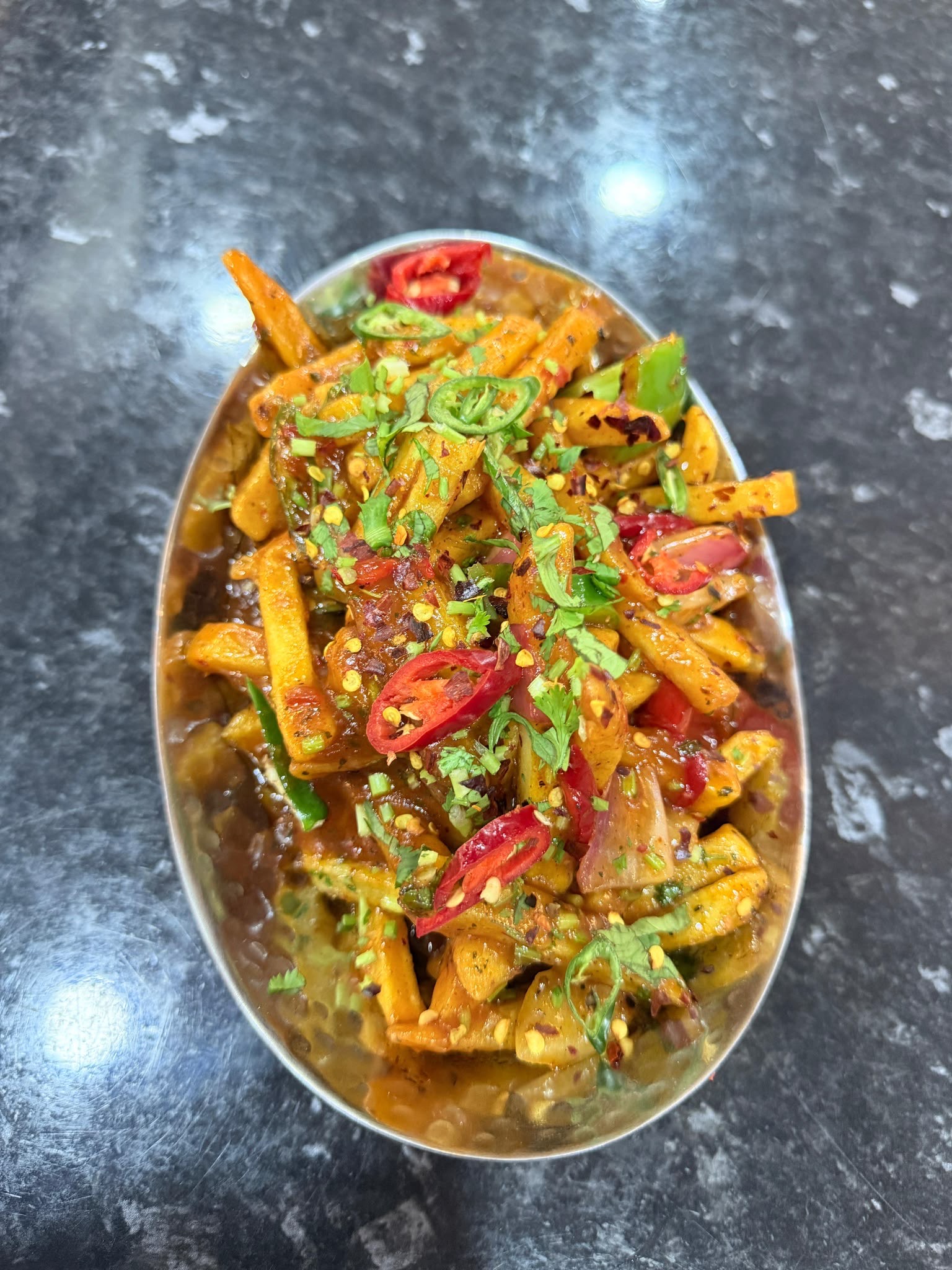 Masala chips loaded with spiced tomato sauce and fresh chillies at Lahore Qila