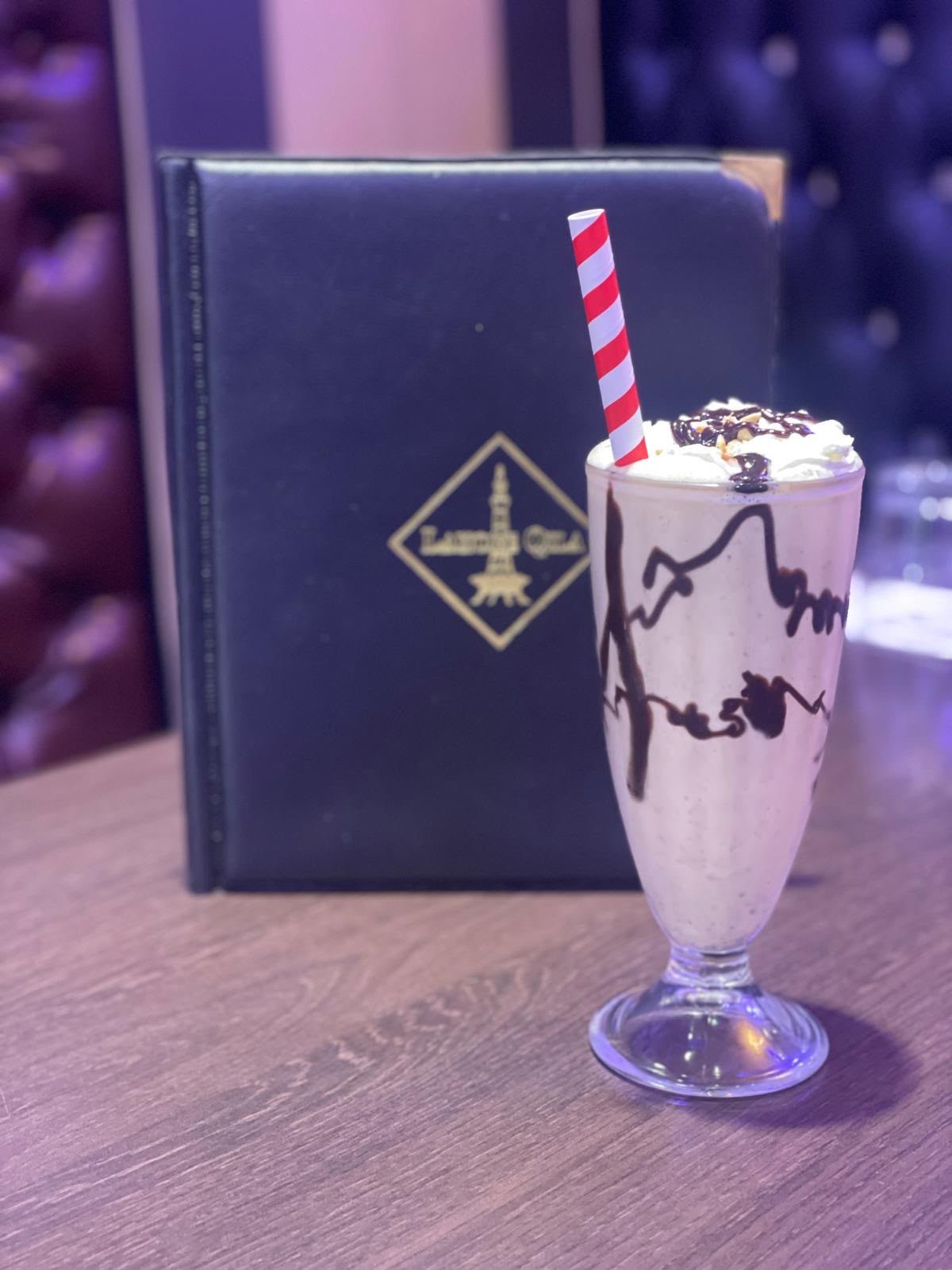 Milkshake and branded Lahore Qila menu on the table inside the restaurant