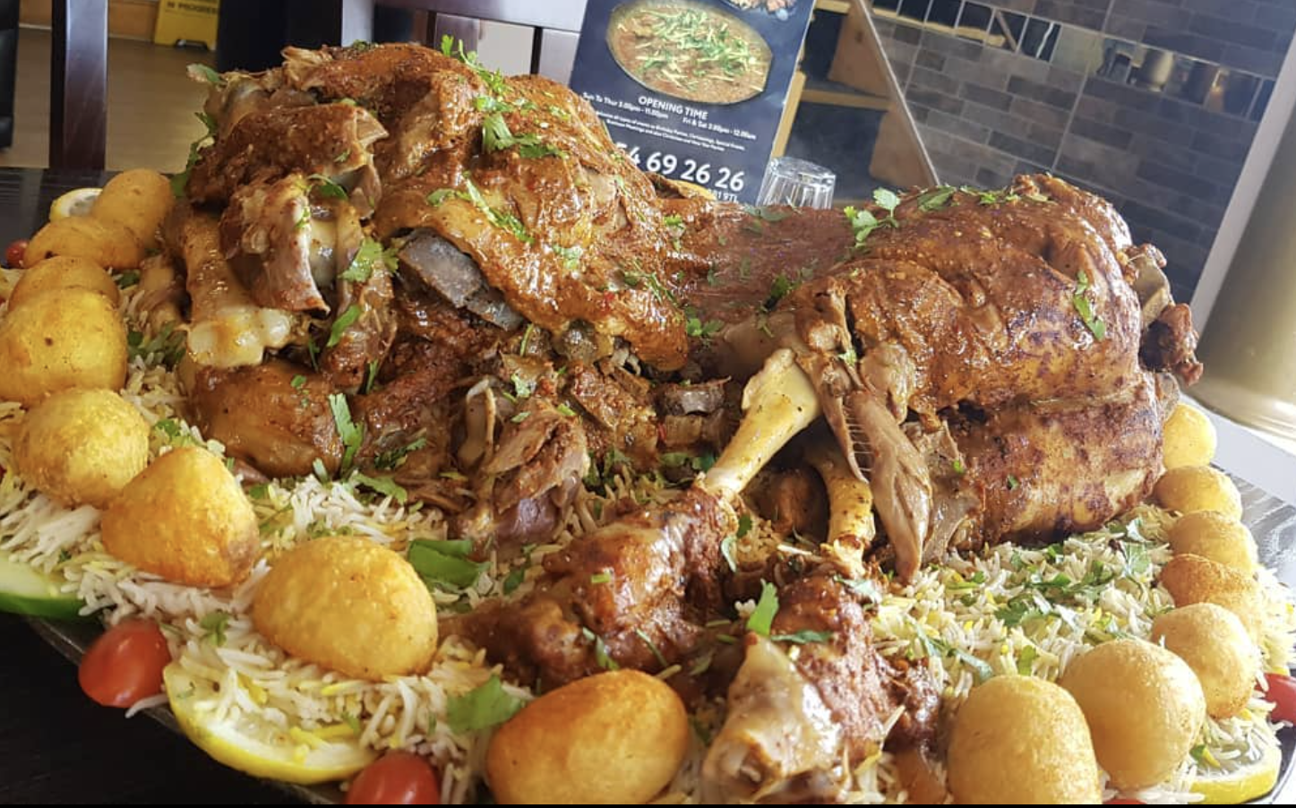Slow-cooked lamb leg raan served with rice and naan at Lahore Qila