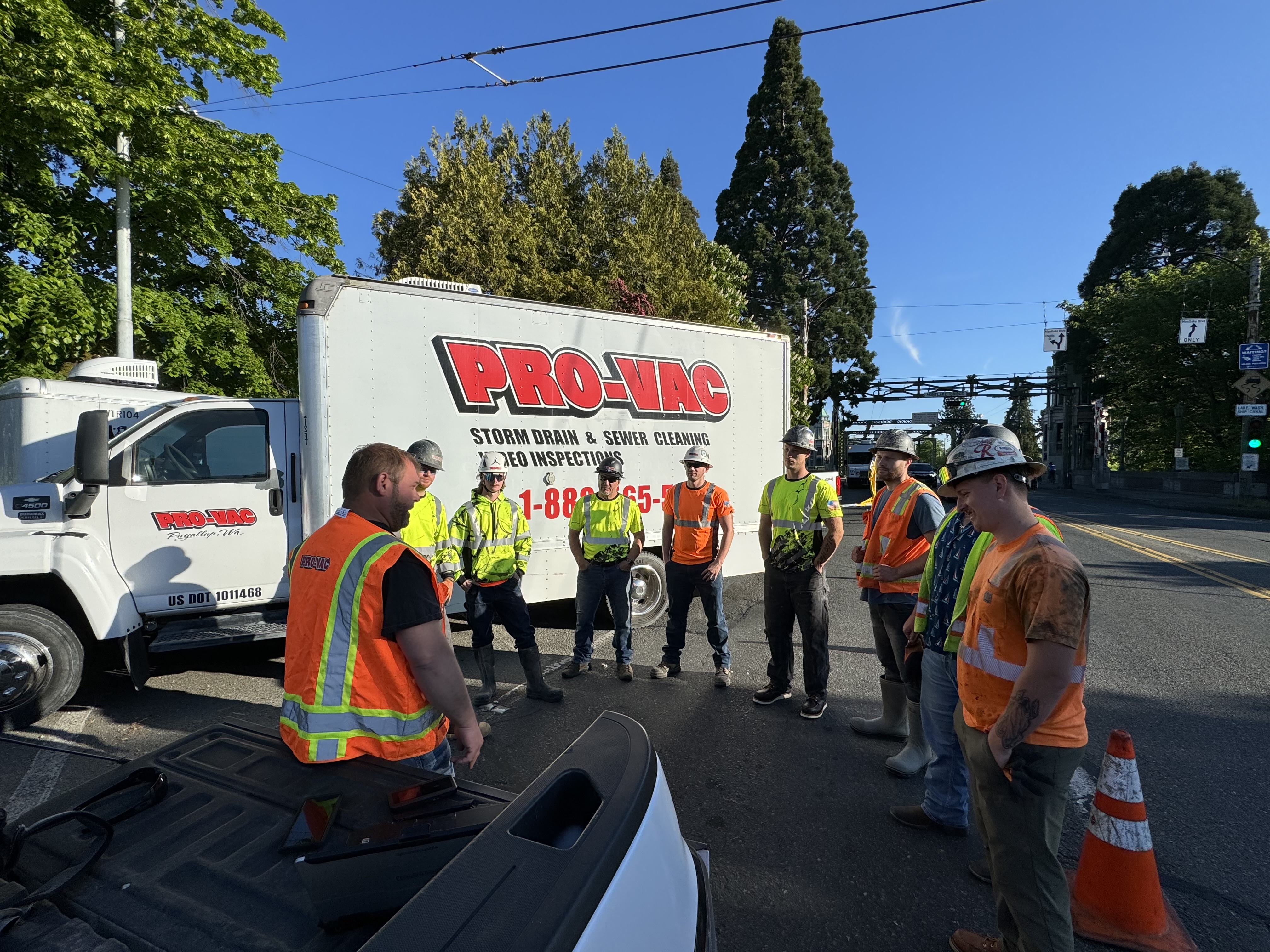 A Pro-Vac branch crew standing in front of their hydrovac trucks