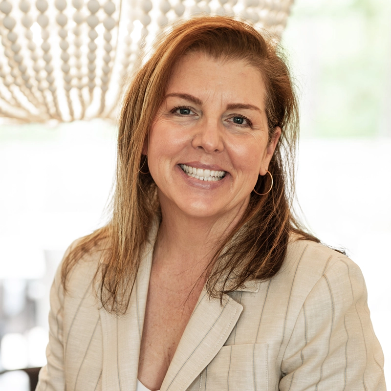 Kristin Moore in a cream pinstripe blazer, smiling. Founder and Chief Growth Officer of Growth Studio.