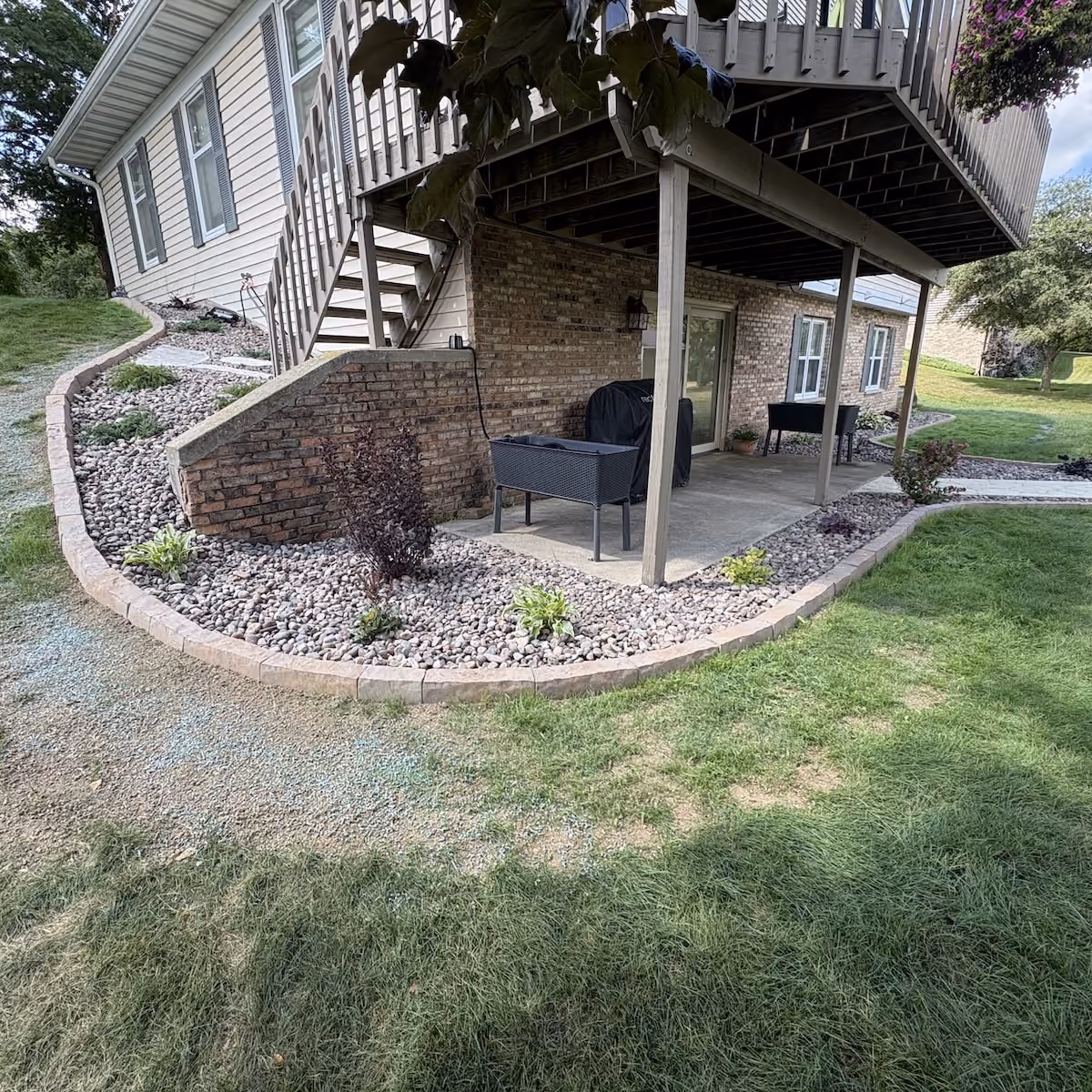 Fresh landscape bed installation with plants flowers and decorative stone