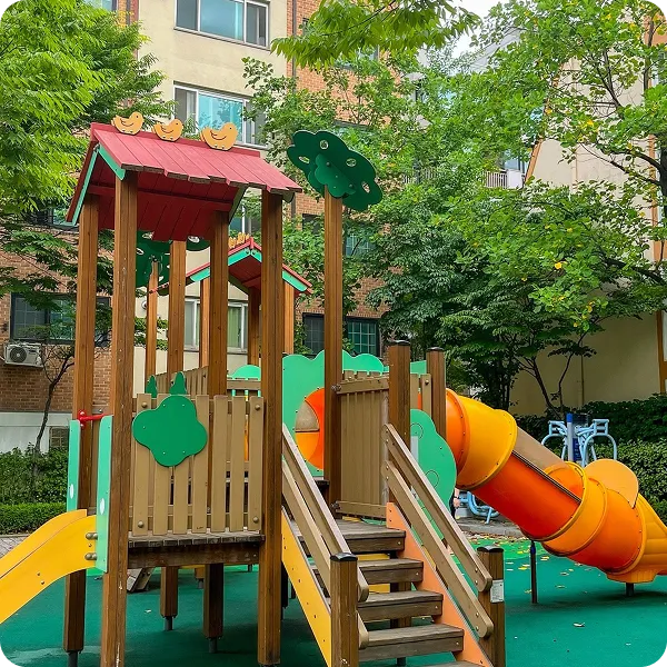 Wooden playground structure with stairs, slides, and colorful nature-themed panels