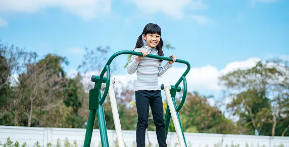 Girls exercising together on outdoor playground equipment