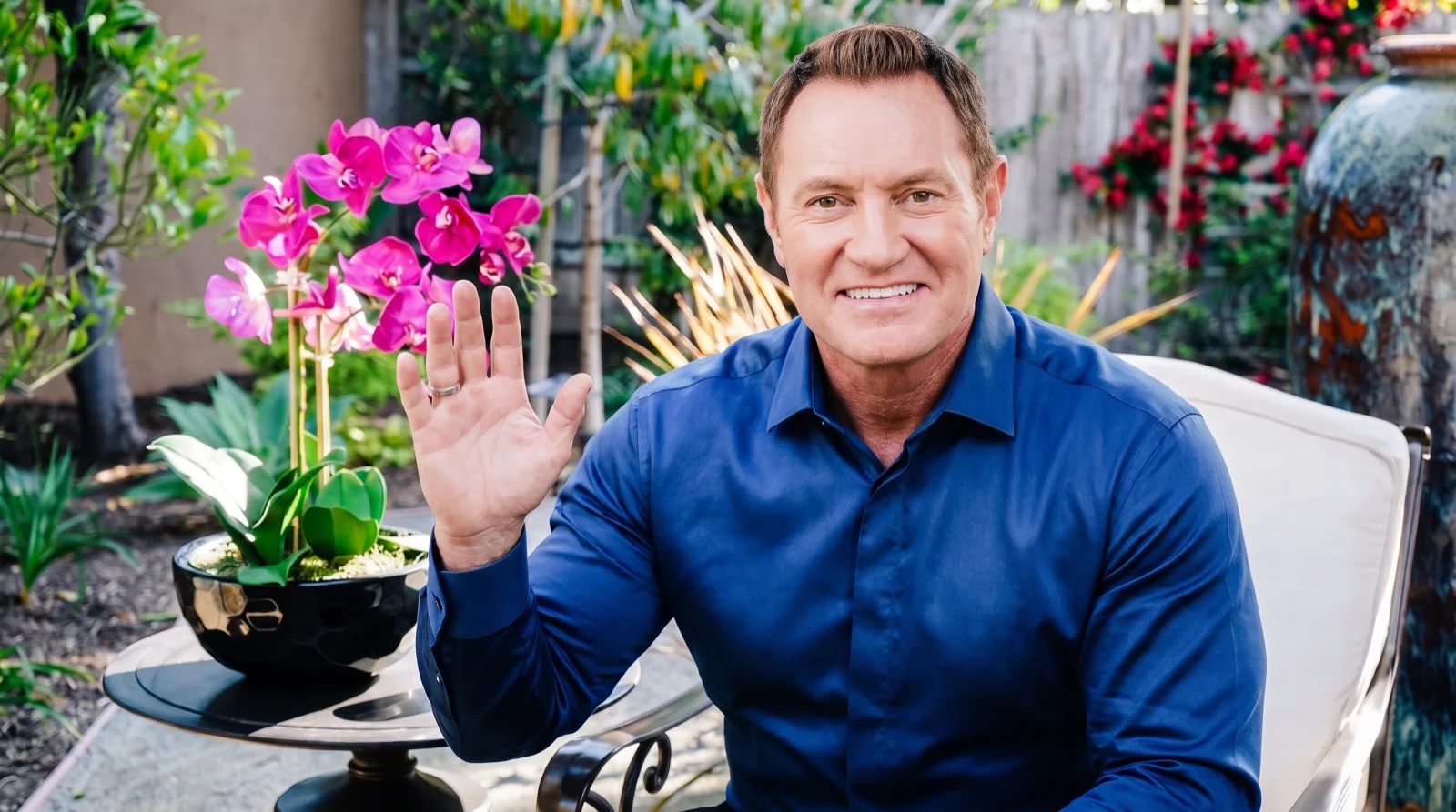 Darren Hardy waving hello on the DarrenDaily garden set