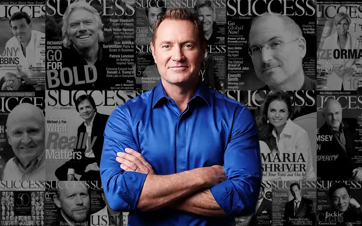 Darren Hardy in front of the wall of SUCCESS magazine covers he published