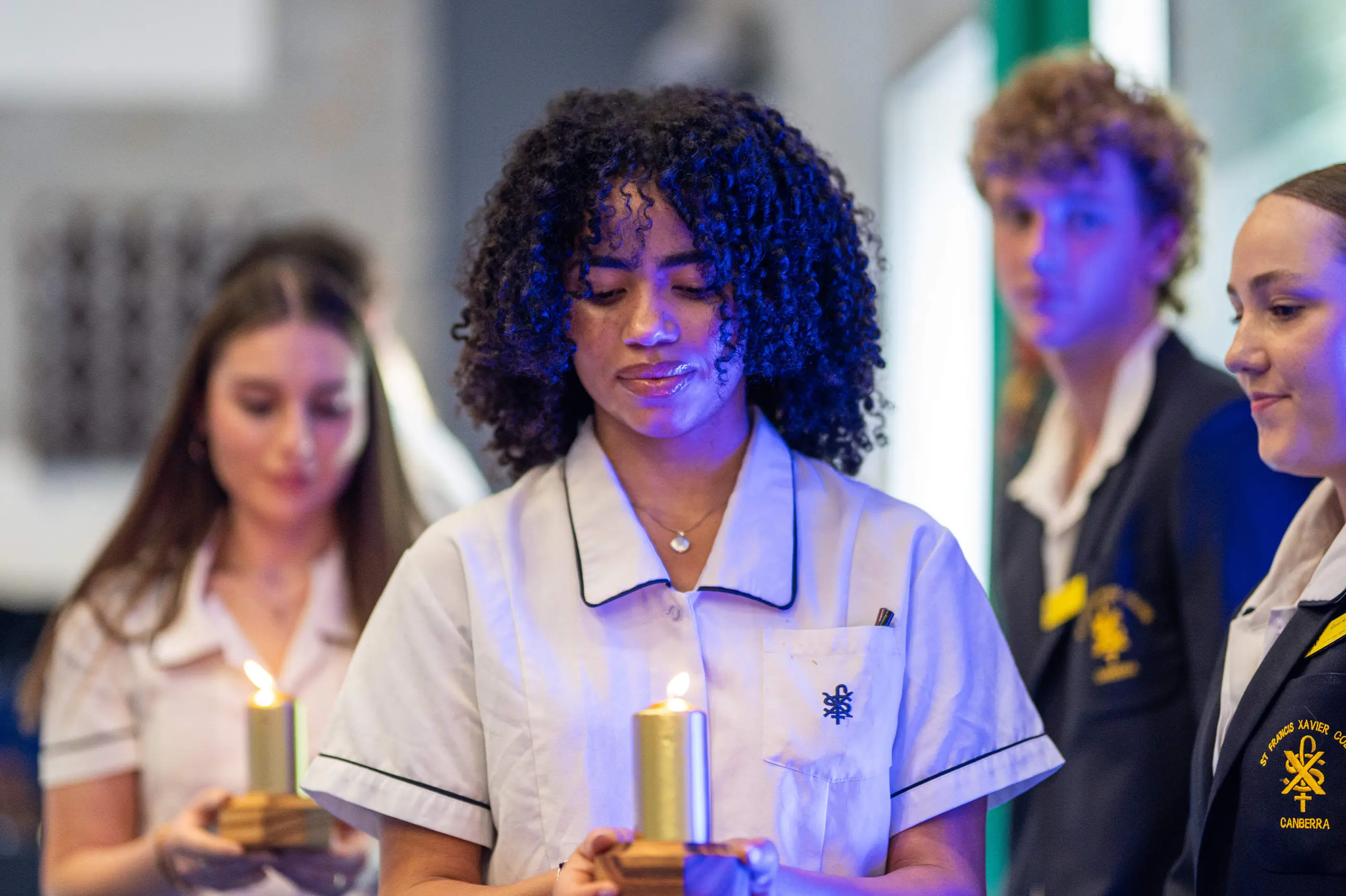 Secondary school students holding candles during a liturgy