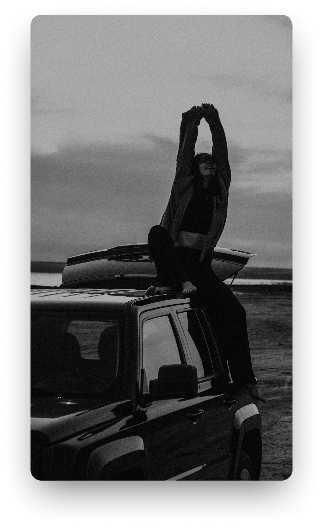 A person standing on the roof of a parked truck, looking out over open country. An illustration, not a real member's plan.