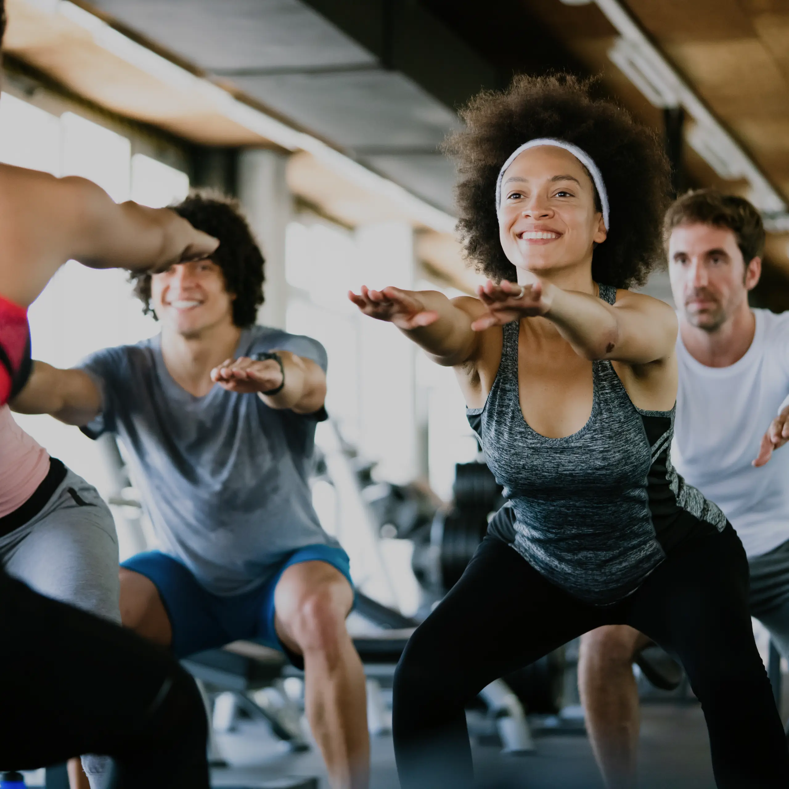People doing squatting in a gym