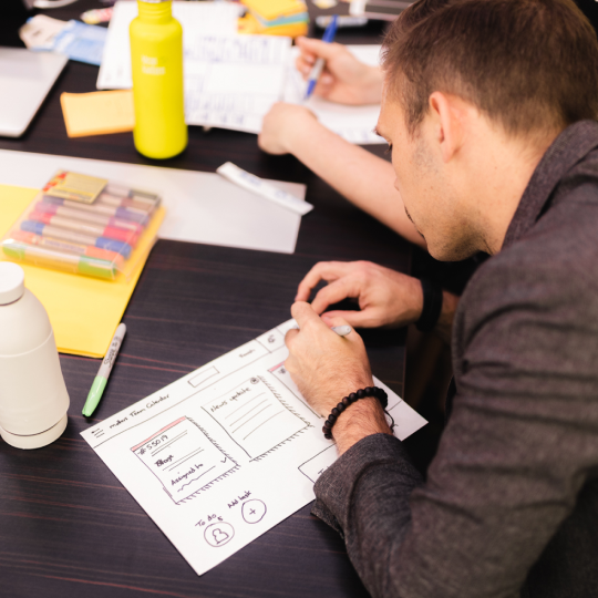 A person sketching wireframes in a workshop