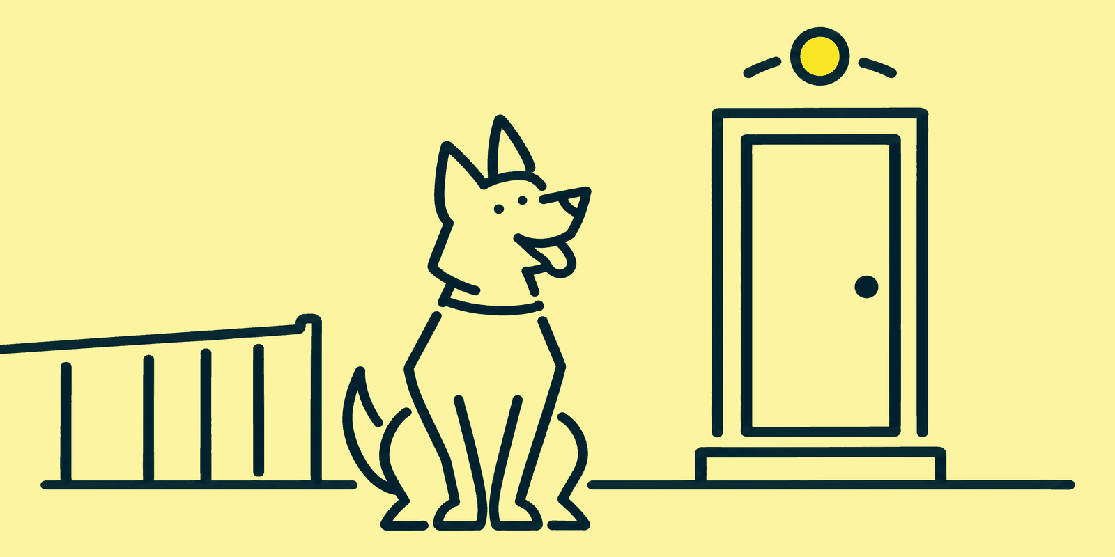 A German shepherd sits smiling with its head tilted in a back garden beside a closed back door with a small step, a round sensor light glowing on the wall above it, and a low fence running off behind the dog.
