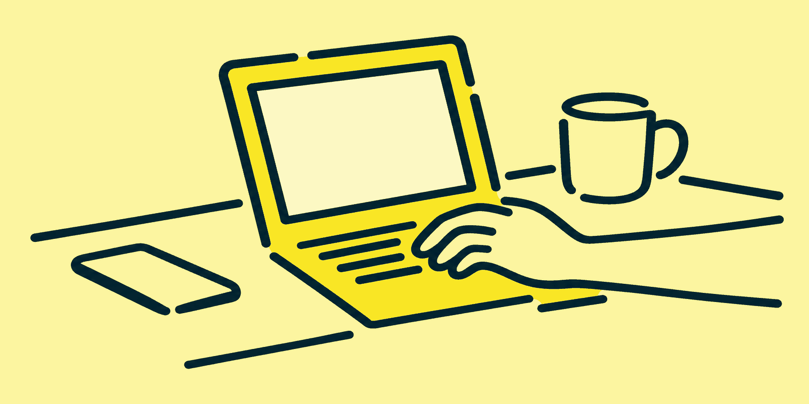 A person types on an open laptop showing a blank post block on a kitchen table, with a phone face up at the left edge and a mug behind the laptop at the back right corner.