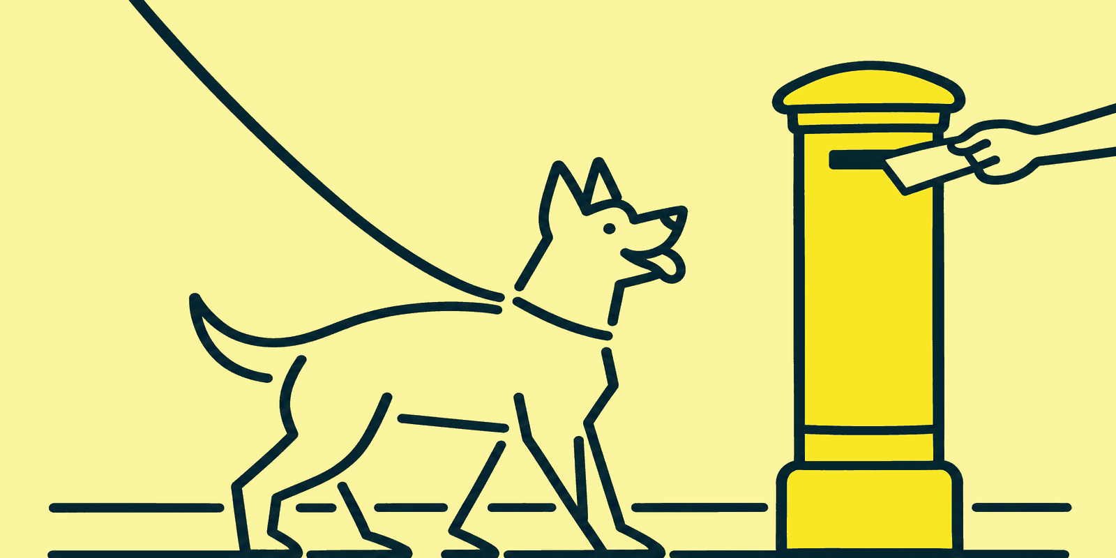 A German shepherd on a lead looks up at a hand posting a letter into a tall postbox on a quiet street.