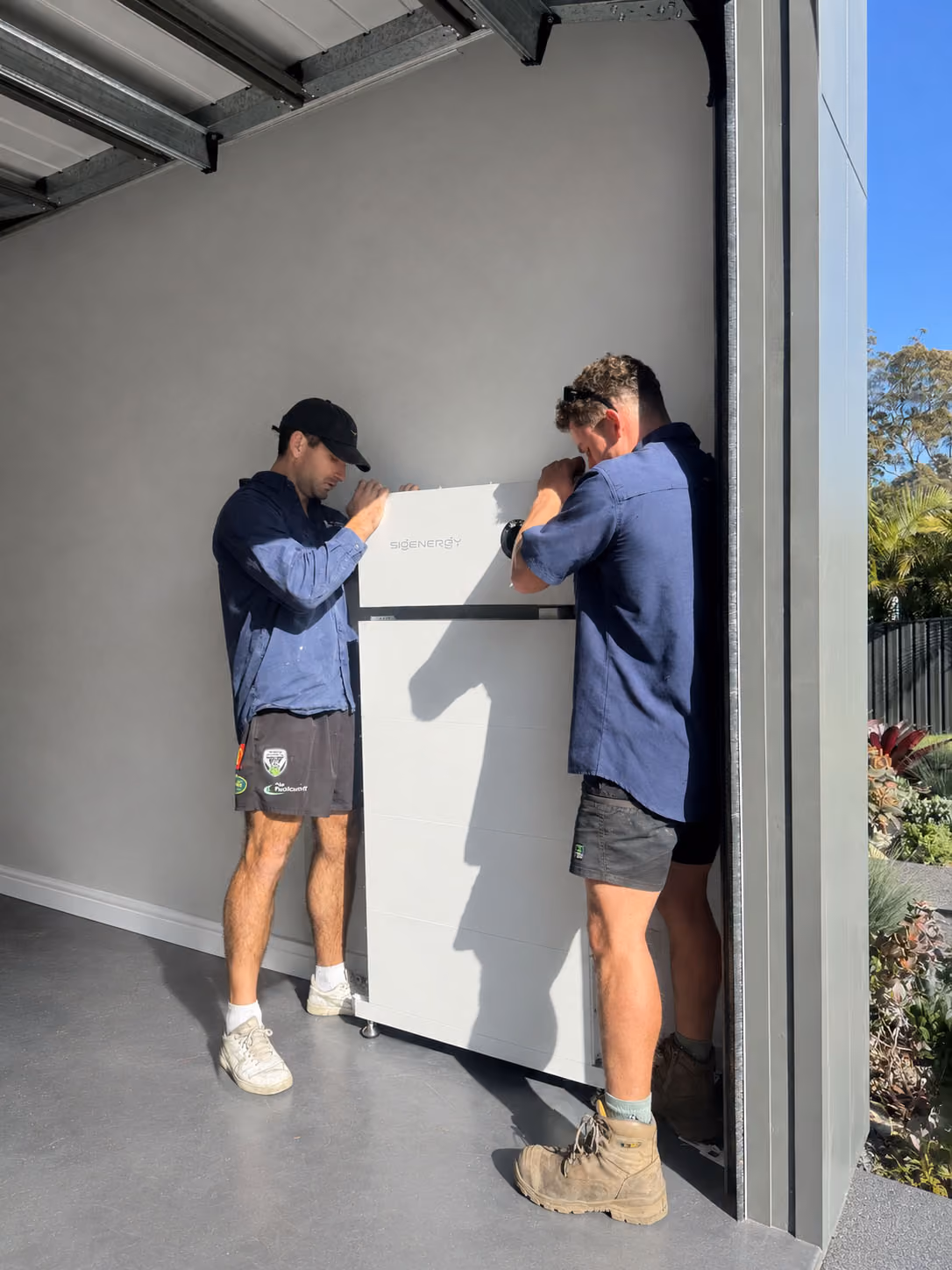 Two men holding a battery