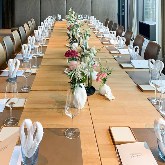 Festlich gedeckte lange Tafel mit Blumen – Hochzeit im Restaurant JOHANNS
