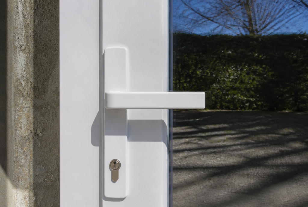 Detail de la poignee blanche et des profiles PVC de la porte vitree