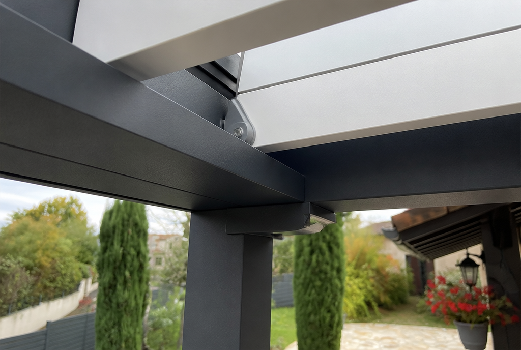 Gros plan sur les lames orientables blanches et la poutre aluminium anthracite de la pergola