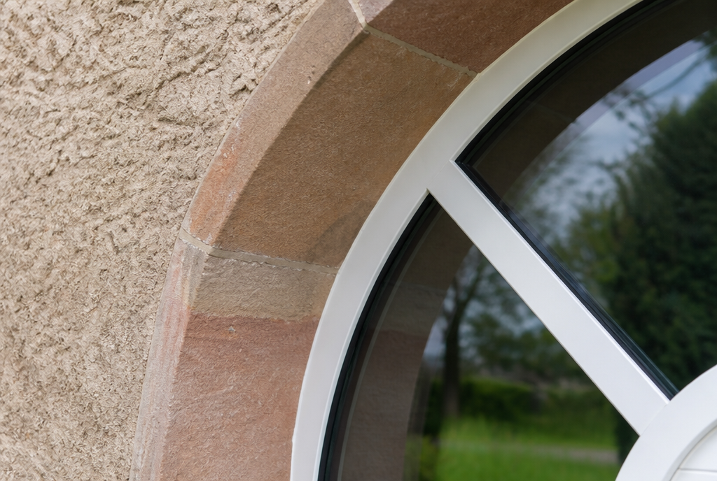 Gros plan sur les petits bois rayonnants et l'encadrement en gres rose