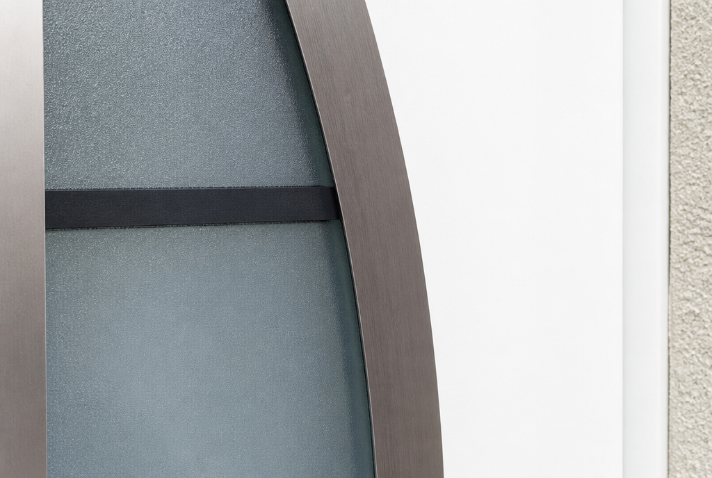 Détail du cadre incurvé bronze et du vitrage sérigraphié de la porte blanche