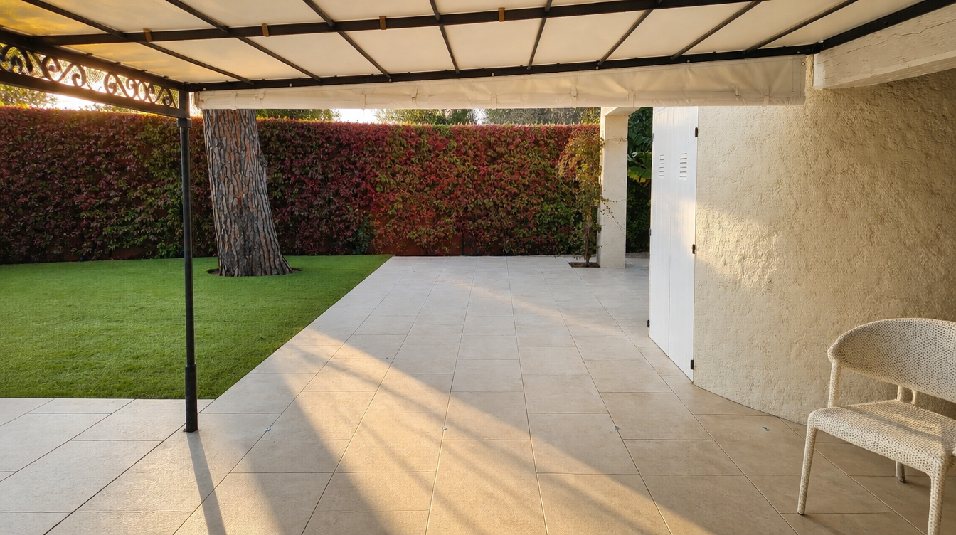 Ambiance de fin de journée, rideaux relevés et terrasse ouverte sur le jardin