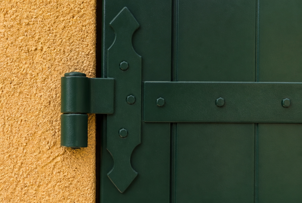 Detail d'une penture et d'un gond sur le volet aluminium vert a lames verticales