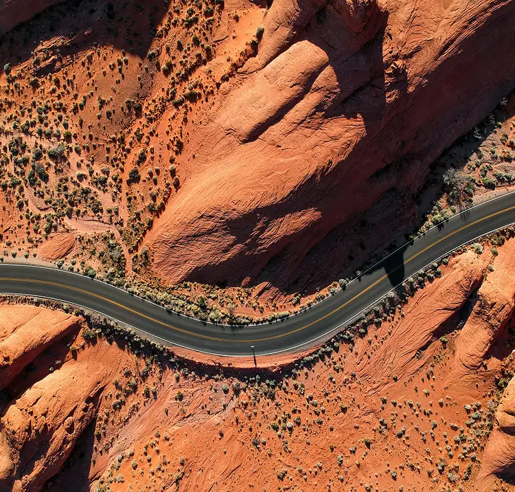 Aerial view of a highway winding through red rock canyon country