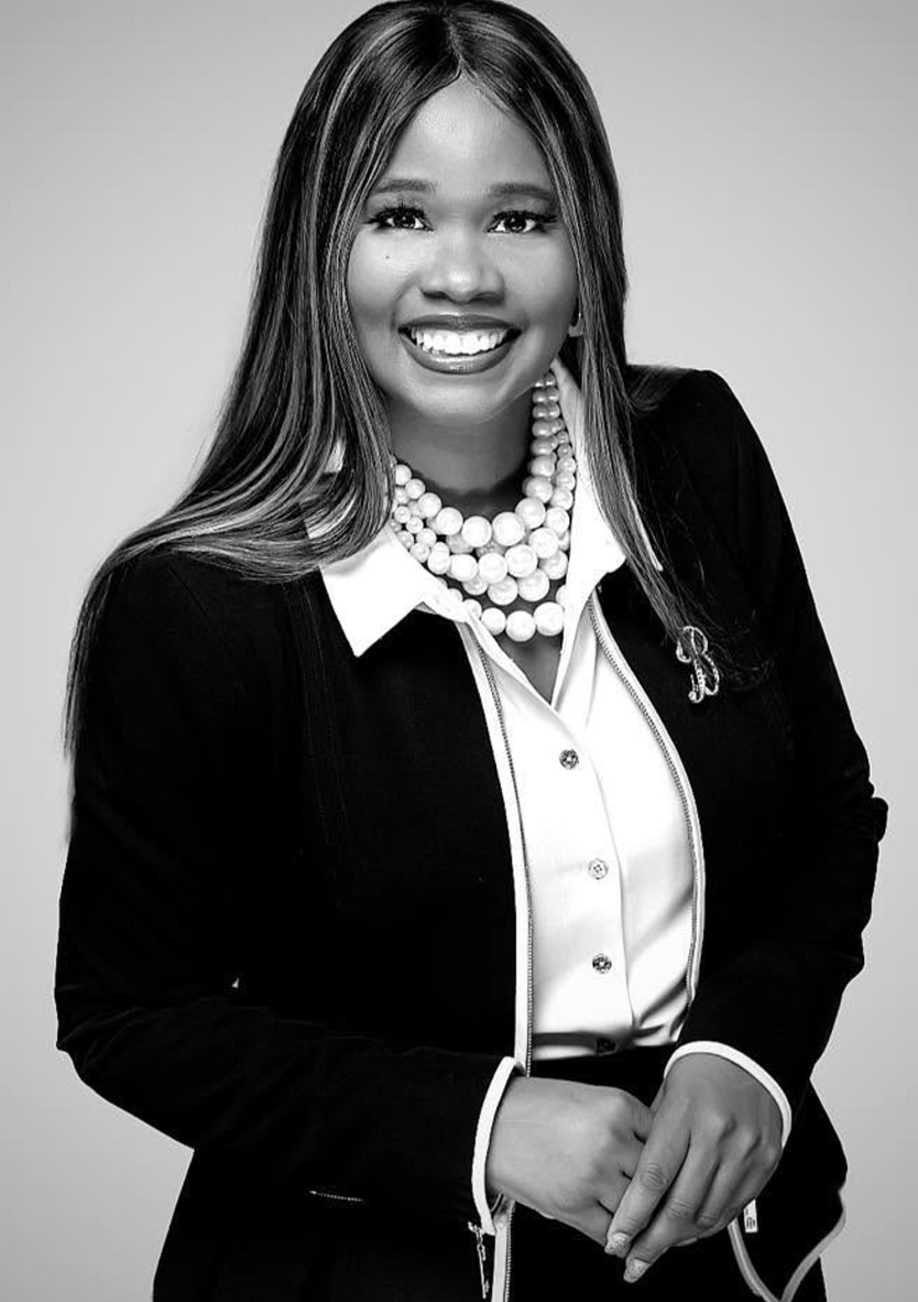 Black-and-white professional headshot of Pastor Bessie, a Chrysallis Lab client, smiling in a black blazer and pearl necklace