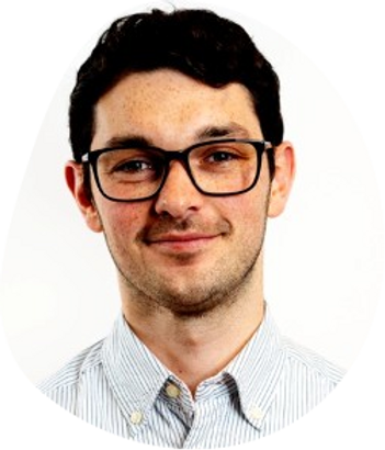 Smiling man with glasses in a striped shirt against a plain white background, exuding a friendly and approachable mood.