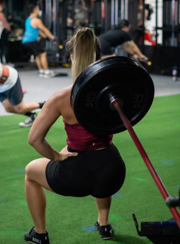 Athlete performing a heavy barbell back squat at House of Strength in San Diego, CA.