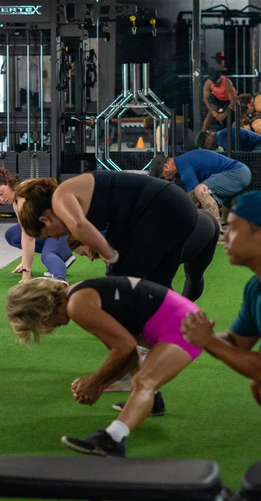 Group fitness class performing floor exercises together at House of Strength in San Diego, CA.